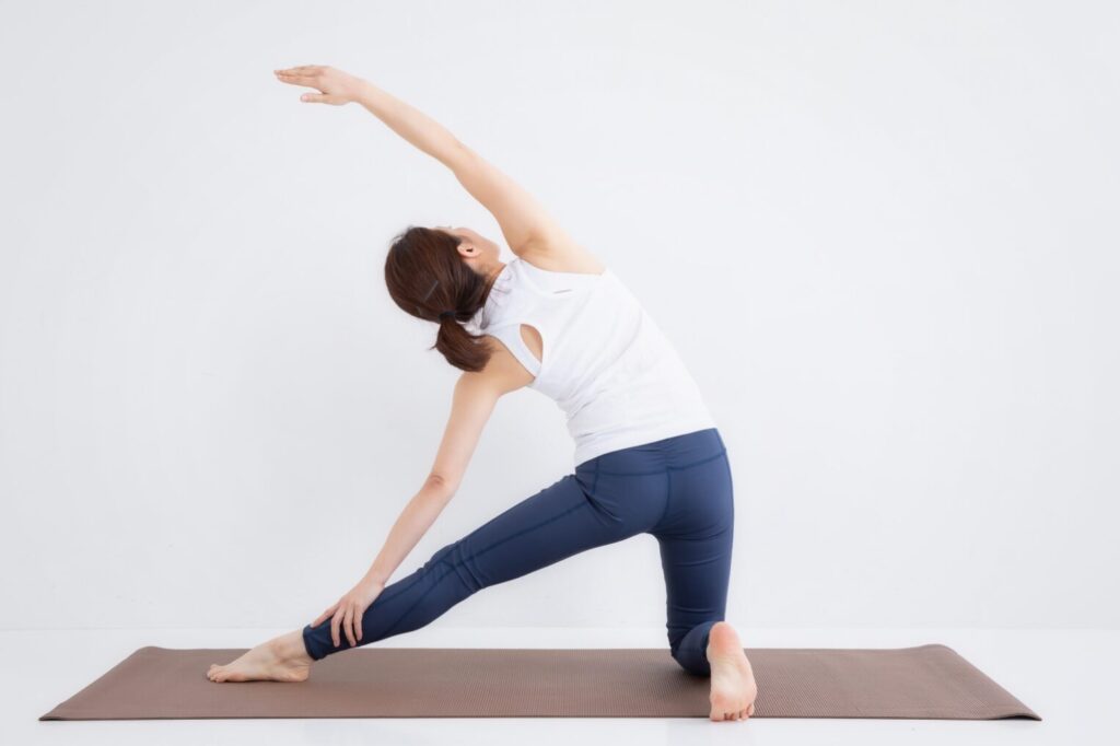ヨガのポーズで体側を伸ばすストレッチをしている女性