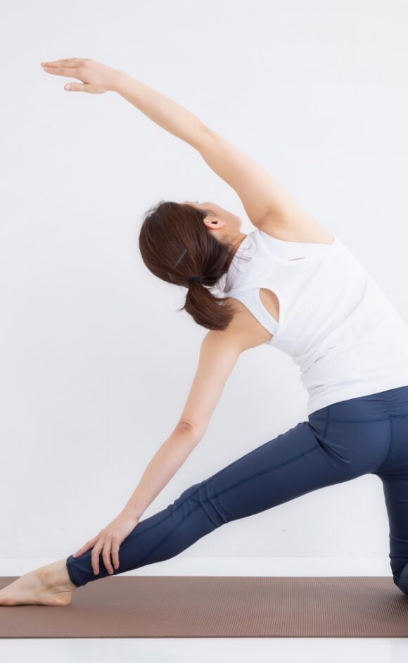ヨガのポーズで体側を伸ばすストレッチをしている女性