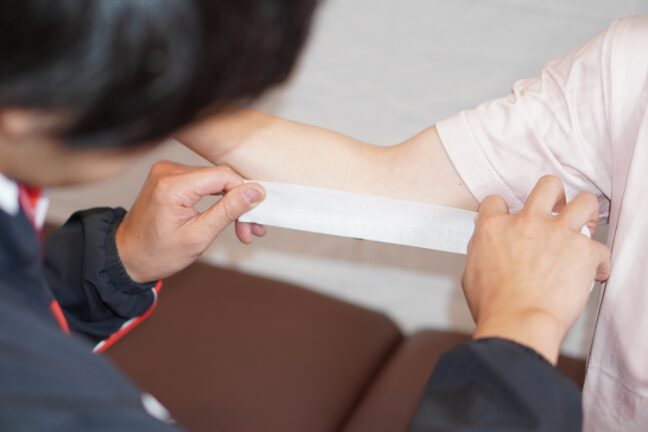 肘にテーピングをしている様子